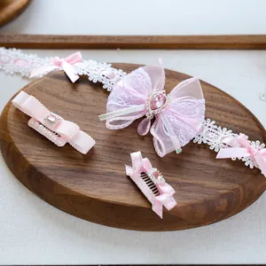 Macro detail of pink pet hair accessories set featuring lace bows, pearls and rhinestones
