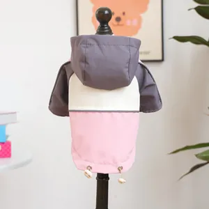 Detail of dog windbreaker featuring pink-grey color block design and adjustable drawstring