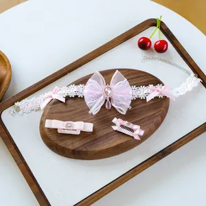 Detailed view of pink lace pet collar and hair clips with bowknots and faux crystals