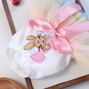 Close-up of pet dress with rabbit embroidery, pink satin bow and rainbow tulle skirt