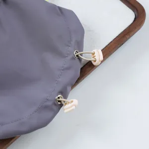 Close-up of dog hooded jacket showing beige drawstring toggle and metal eyelet detail