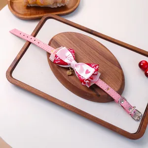 Détail du collier rose pour chat et chien avec nœud et pendentif cœur doré élégant