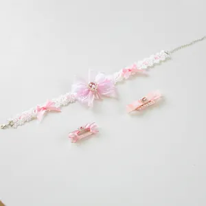 Detail of pink Lolita style lace pet choker and matching bow hair clips with faux gems