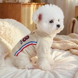 Detail of cream dog sweater with sports embroidery and integrated leash D-ring