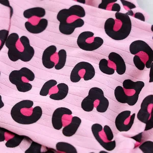 Dettaglio del tessuto a maglia leopardato rosa con trama a costine e piccoli trafori