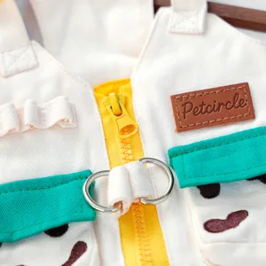 Detail of pet vest showing green pocket, yellow zipper and metal D-rings for leash