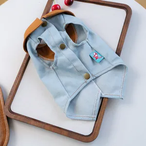 Detail der hellblauen Denim Haustierweste mit Cordkragen und Knöpfen auf Holzgrund