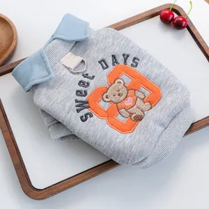 Detail eines grauen Haustier-Sweatshirts mit Teddybär-Stickerei und Metall-D-Ring