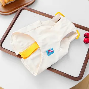Close-up of off-white cotton pet vest with yellow straps and blue pocket detail