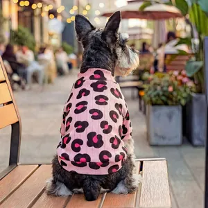 Felpa rosa maculata per cani di piccola taglia indossata su una sedia esterna