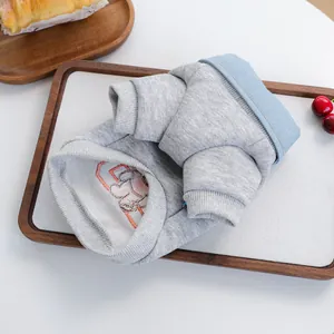 Detailansicht eines grauen Haustier-Pullovers mit blauem Denim-Kragen und Stickerei