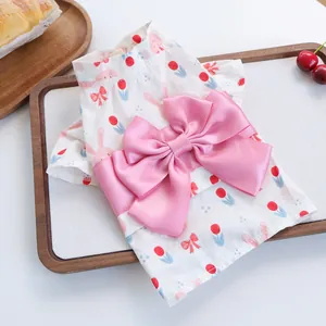 Bloemige zomerjurk voor huisdieren met roze konijnenmotief en een grote satijnen strik