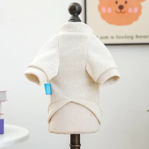 Close-up of cream ribbed knit pet sweater featuring brand logo tag and turtleneck