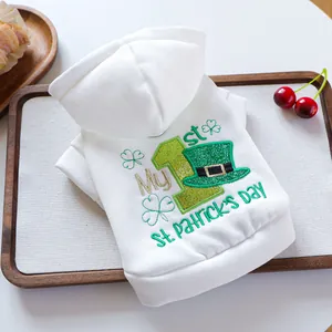 White St. Patrick's Day pet hoodie with clover embroidery on a wooden tray