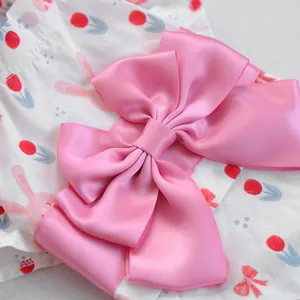 Macro-detail van de roze satijnen strik en bloemrijk konijnenpatroon op huisdier yukata