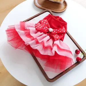 Detail of red pet dress showing layers of mesh gauze and heart bow with shiny crystal