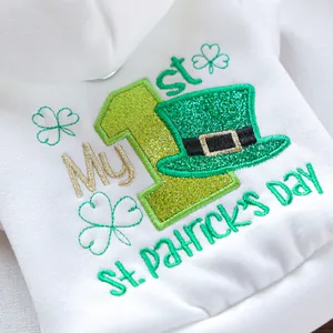 Detail view of embroidered My 1st St. Patrick's Day clover and hat design on white dog hoodie