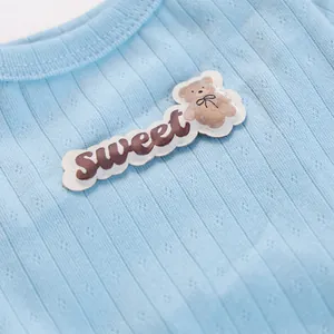 Detail von hellblauem Rippstrick-Haustierpullover mit süßem Bären-Aufnäher und Sweet-Text