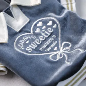 Macro shot of white heart embroidery with Sweetie text on navy velvet pet polo shirt
