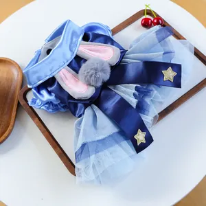 Detailed view of the blue satin pet dress with rabbit ears and golden star sequins