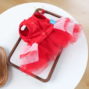 Detail of red and pink mesh tutu dress for small dogs on a wooden tray with cherry decor