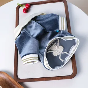 Detail of blue-grey velvet pet polo shirt with gold stripe trim and embroidery