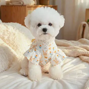 Detail van lichtblauw huisdierenshirt met tulp- en konijnpatronen op een Bichon Frise