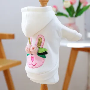 Detail of white pet hoodie featuring pink bunny embroidery and 3D silk flower accents