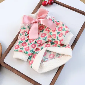 Detail of floral pet knitwear featuring pink satin bow and delicate lace trim for small dogs