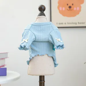 Detail von hellblauem Haustierpullover mit weißen Schleifen und Rüschen am Hundemodell