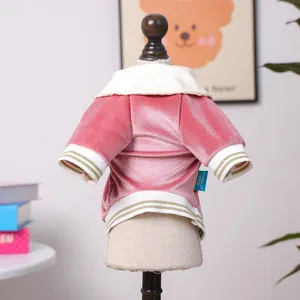 Detail view of pink velvet pet polo shirt with gold-striped ribbed cuffs and brand tag