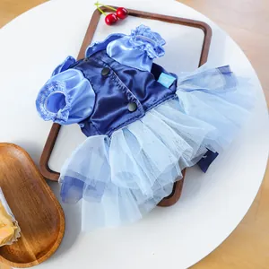 Detail of blue pet princess dress with satin bodice and layered tulle skirt on wooden tray