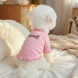Detail des rosa gestrickten Hundepullovers mit Bärenstickerei und Rüschensaum