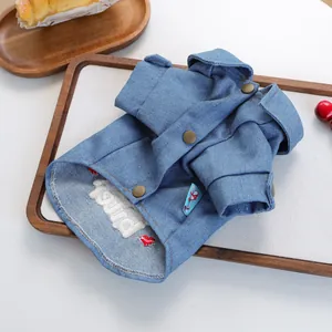 Detail of pet denim jacket with white towel embroidery and heart on a wooden tray