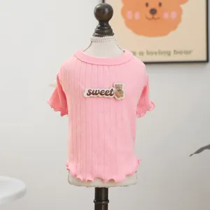 Detail eines rosa Strickpullovers für Haustiere mit Bären-Patch und gewelltem Saum