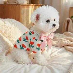 Detail of dog knit sweater featuring tulip patterns, lace collar and pink satin bow