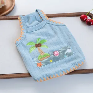 Light blue knit pet vest with tropical embroidery on a white textured background