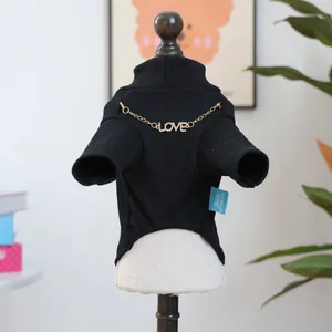 Detail van zwarte coltrui voor huisdieren met gouden LOVE-ketting en ribgebreide textuur
