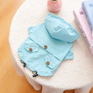 Détail d'imperméable bleu clair pour animaux avec boutons métalliques et cordon réglable