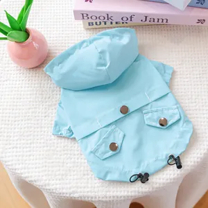 Close-up of light blue pet raincoat showing waterproof fabric and decorative back pockets