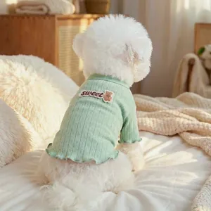Detail der mintgrünen gerippten Tierstrickware mit süßer Bärenstickerei auf weißem Hund