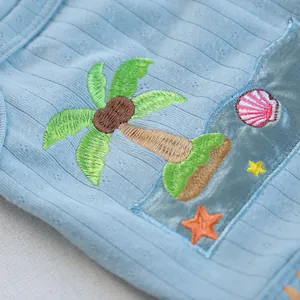 Detailed macro view of coconut tree and starfish embroidery on blue ribbed pet vest