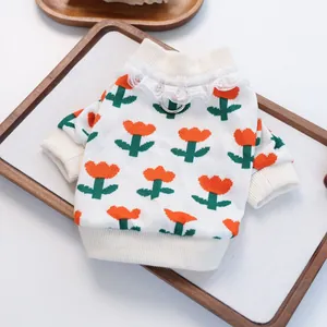Close-up of knit pet sweater featuring orange tulips, lace collar, and metal D-ring attachment