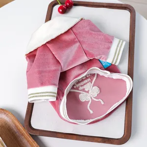 Close-up of pink velvet pet polo shirt with white bow embroidery and rib cuffs