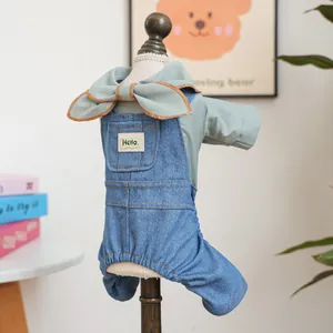 Detail of pet clothing set with a light green bow top and denim overalls on a small hanger