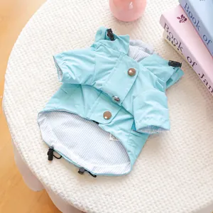 Détail de l'imperméable bleu pour chien avec capuche, boutons et doublure rayée