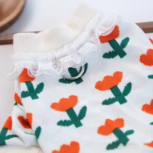 Detail of dog sweater with floral jacquard pattern, lace collar and metal D-ring for leash