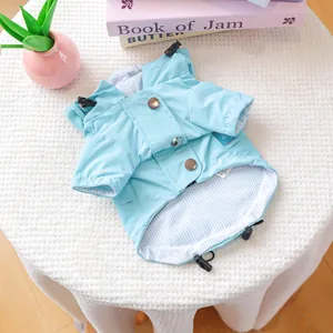 Detail of light blue pet raincoat showing metal snap buttons and striped lining detail