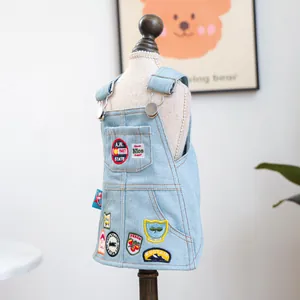 Detail van de lichtblauwe denim hondenjurk met kleurrijke borduursels en metalen gespen