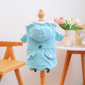 Detail of light blue waterproof dog raincoat with hood, pocket, and adjustable drawstrings
